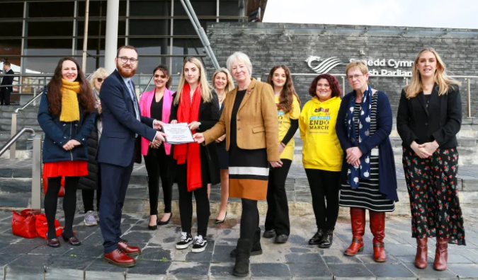 Beth hands in the petition to the Senedd with Jenny Rathbone MS, supportive MSes and FTWWers